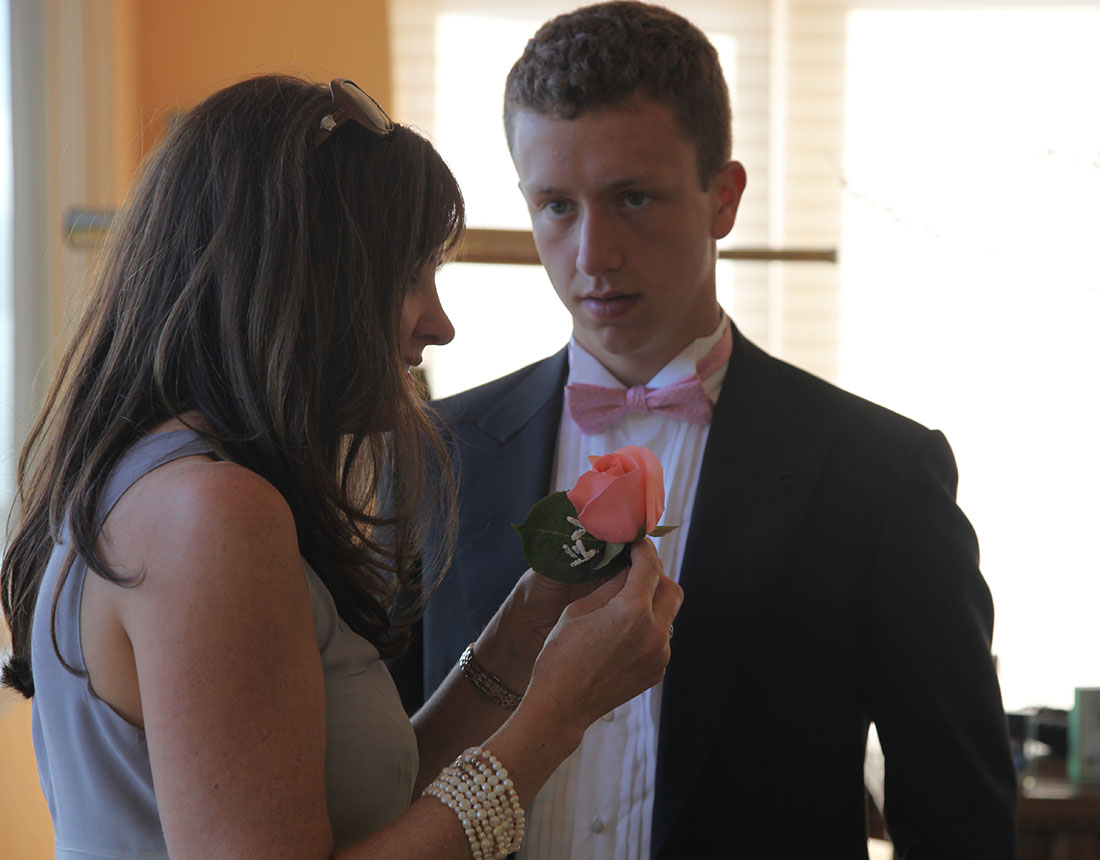Jennifer pinning flowers onto Ryan's tux