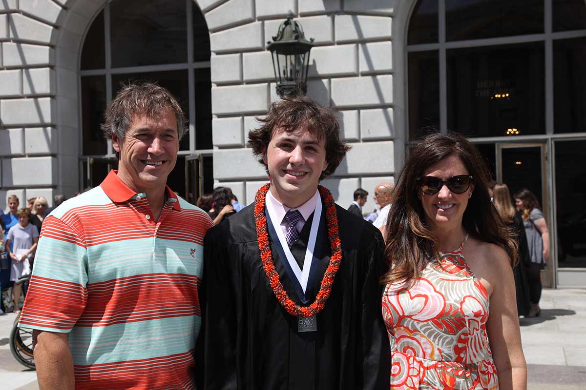Sammy and parents on graduation day